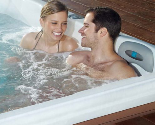 Couple relaxing in their hot tub by Artesian Spas