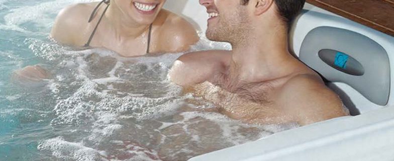 Couple relaxing in their hot tub by Artesian Spas