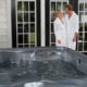 Happy couple in front of hot tub after learning the secret to easy spa care